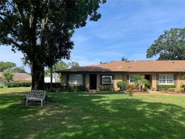 Cute condo with a manicured lawn and a large tree at 3259 Hilary Cir # 1A, Palm Harbor, FL 34684