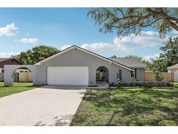 Charming single-story home features a manicured lawn, a gray exterior, and a two-car garage at 1009 Black Knight Dr, Valrico, FL 33594