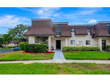 Inviting exterior of a two-story condo with landscaped grounds at 7020 Cognac Dr # 3, New Port Richey, FL 34653