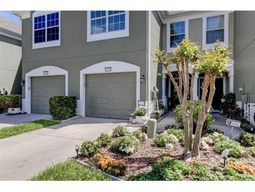 Two-car garage, well-maintained landscaping, and inviting front entrance at 10280 Post Harvest Dr, Riverview, FL 33578