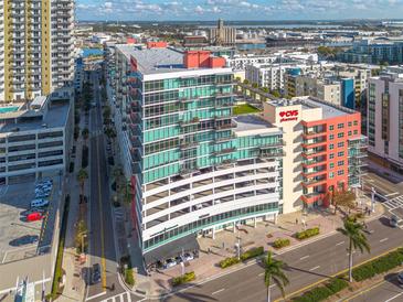 Aerial view of a modern building complex with ample parking and city views at 1120 E Kennedy Blvd # 1221, Tampa, FL 33602