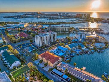 Aerial view of waterfront community with upscale homes and marina at sunset at 354 Larboard Way, Clearwater Beach, FL 33767