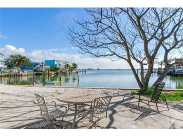 Relaxing waterfront patio with table and chairs, offering scenic views at 409 161St Ave, Redington Beach, FL 33708