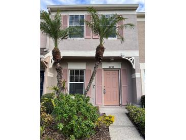 Inviting exterior of townhome with pink door and landscaping at 6232 Bayside Key Dr, Tampa, FL 33615