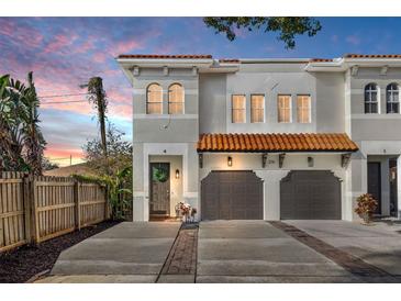 Charming townhome featuring a terra cotta roof, attached two-car garage, and welcoming front door with a wreath at 216 S Westland Ave # 4, Tampa, FL 33606