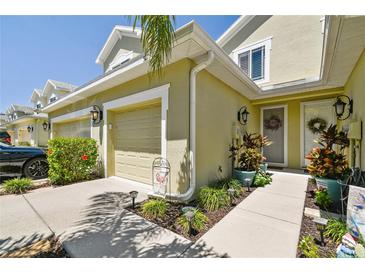 Attractive townhome exterior with landscaping and a two-car garage at 521 Harbor Ridge Dr, Palm Harbor, FL 34683