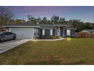 Gray house with a white garage door and landscaped lawn at 6103 Fairway Dr, Ridge Manor, FL 33523