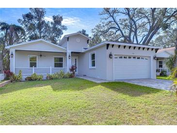 Newly constructed home with gray exterior, landscaping, and a two-car garage at 3125 Downing St, Clearwater, FL 33759