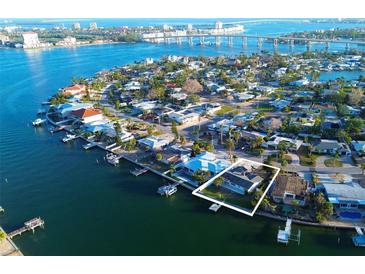 Aerial view of waterfront home with private dock and lush landscaping at 380 Belle Point Dr, St Pete Beach, FL 33706