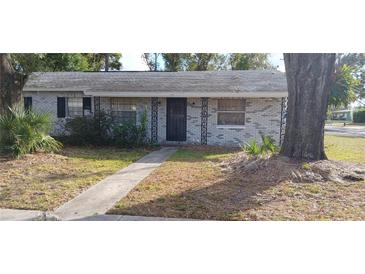 Brick house with a walkway, landscaping, and a large tree in the front yard at 816 W 130Th Ave, Tampa, FL 33612