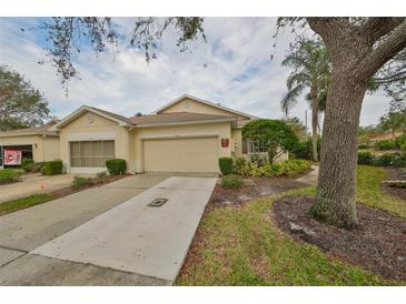 Front view of charming house with attached garage and well-manicured landscaping at 2620 Newcomb Ct, Sun City Center, FL 33573