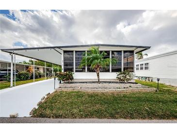 White single-wide manufactured home with carport and palm tree landscaping at 18675 Us Highway 19 N # 421, Clearwater, FL 33764