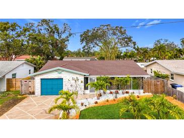 Attractive single-story home with teal garage door and landscaped yard at 5529 11Th N Ave, St Petersburg, FL 33710