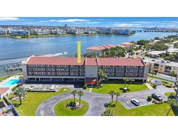 Aerial view of condo building showcasing water views and parking at 8701 Blind Pass Rd # 306B, St Pete Beach, FL 33706