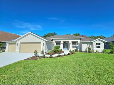 Single-story home with three-car garage and landscaped lawn at 295 Woodstream Way, Spring Hill, FL 34608