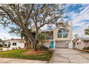 Charming two-story coastal home featuring a bright blue front door and lush landscaping in a beautiful waterfront community at 5946 Bayou Grande Ne Blvd, St Petersburg, FL 33703