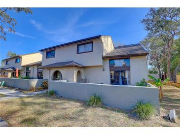 Two-story townhome with a gray exterior, landscaping, and a private patio at 6262 142Nd N Ave # 505, Clearwater, FL 33760