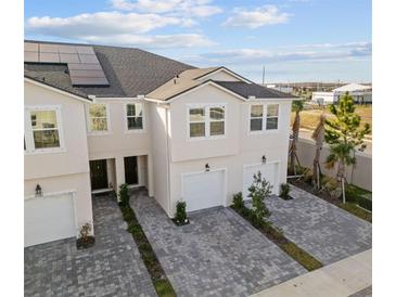 This aerial view shows a townhome with a paved driveway, solar panels, and well-maintained landscaping at 2391 Summerlit St, Lutz, FL 33558