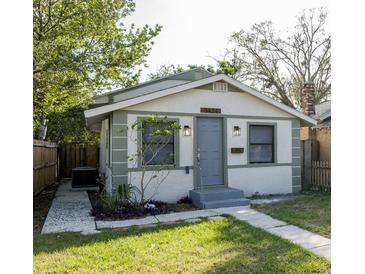 Charming single-story home featuring a blue front door, landscaped yard, and a well-maintained lawn at 3424 Queensboro S Ave, St Petersburg, FL 33711