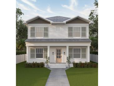 Two-story home with gray roof, white siding, and a welcoming front porch at 1038 25Th N Ave, St Petersburg, FL 33704