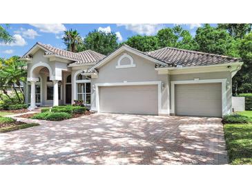 Beautiful home exterior features a two-car garage, paved driveway, manicured landscaping, and a tile roof at 10106 Radcliffe Dr, Tampa, FL 33626