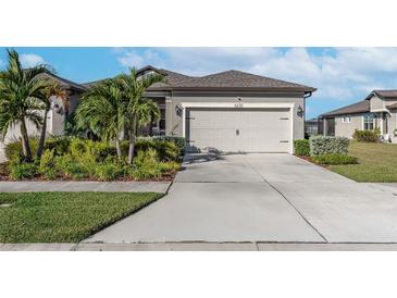 House exterior featuring a two-car garage and well-manicured landscaping at 6230 Mooring Line Cir, Apollo Beach, FL 33572