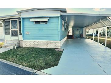 Blue mobile home with carport and landscaped lawn at 9790 66Th N St # 330, Pinellas Park, FL 33782