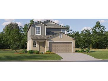 Two-story house with gray and beige siding, two-car garage, and landscaping at 17675 Happytrails St, Land O Lakes, FL 34638