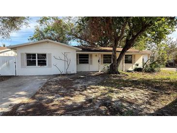 A single story home with a tree in front and driveway at 5641 1St Ne St, St Petersburg, FL 33703