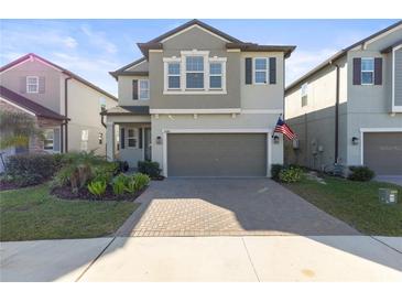 Two-story house with gray siding, gray garage door, and landscaped front yard at 8280 Rolling Tides Dr, New Port Richey, FL 34655