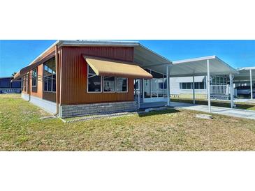 Cozy home with a covered carport and awning to provide shade at 225 N Saint Thomas Cir, Apollo Beach, FL 33572