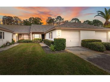 Exterior view of a charming villa with a two-car garage and well-manicured lawn at 3309 Lori Ln, New Port Richey, FL 34655