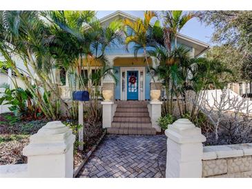 Charming bungalow with a blue facade, lush landscaping, and a welcoming front porch at 115 Athens St, Tarpon Springs, FL 34689