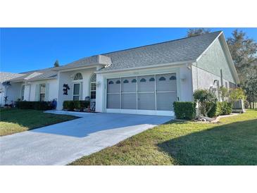 Charming single story home featuring a well-maintained lawn, gray roof and attached two-car garage at 9336 Villa Entrada, New Port Richey, FL 34655