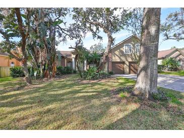 Two-story house with two car garage, mature landscaping and large trees at 2561 Regal River Rd, Valrico, FL 33596