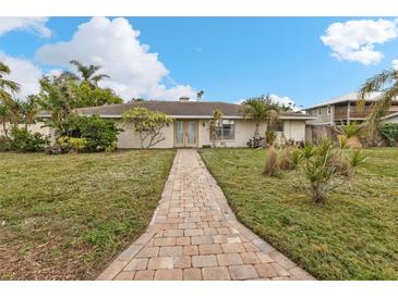 Brick ranch home with a landscaped lawn and brick walkway at 512 Acacia Ln, Nokomis, FL 34275