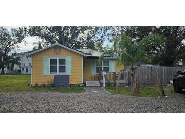 Cute yellow cottage with solar panels, small deck, and fenced yard at 6404 Pershing Ne St, St Petersburg, FL 33702
