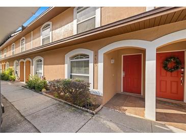 Exterior view of townhouse with red door and landscaping at 14625 Par Club Cir, Tampa, FL 33618