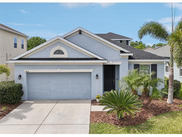 Charming single-Gathering home featuring a two-car garage, well-manicured lawn, and lush landscaping at 4735 Rolling Green Dr, Wesley Chapel, FL 33543