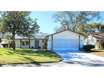 One-story house with attached garage, and landscaped lawn at 8040 Pasadena Dr, Port Richey, FL 34668