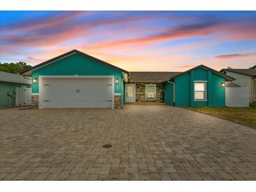 Teal house exterior with paver driveway, 2-car garage, and stone accents at 6926 Williams Dr, Tampa, FL 33634