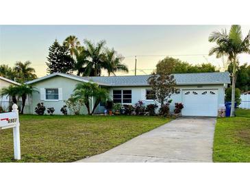 Charming single-story home featuring a well-manicured lawn and an attached garage at 6951 S Shore S Dr, South Pasadena, FL 33707