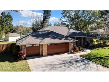 Brick house with a two-car garage and landscaped yard at 19505 Coachlight Way, Lutz, FL 33549