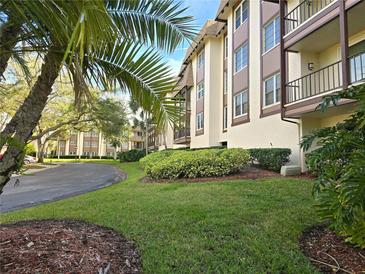 Condominium exterior with lush landscaping and palm tree along a winding driveway at 3031 Countryside Blvd # 35C, Clearwater, FL 33761