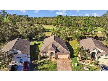 Charming single-Gathering home boasts a manicured lawn and paver driveway in a serene, tree-lined neighborhood with golf course views at 4275 Caskie Pl, Brooksville, FL 34604