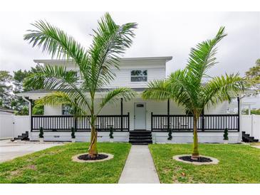 Two-story house with white siding, black accents, and a porch at 7024 Blossom Ave, Tampa, FL 33614