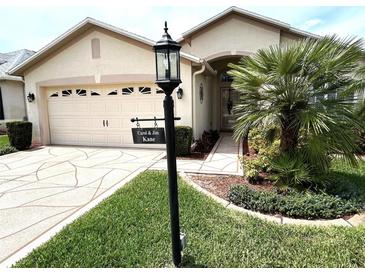 Charming single-story home featuring a two-car garage, manicured lawn, and tropical landscaping at 11021 Edge Park Dr, Hudson, FL 34667