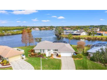 Waterfront home featuring lush landscaping, mature trees, and a charming archway entrance at 7233 15Th Ne Ct, St Petersburg, FL 33702