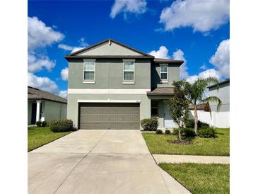 Charming two-story home with a well-manicured lawn, a two-car garage, and pleasant landscaping at 13621 Willow Bluestar Loop, Riverview, FL 33579