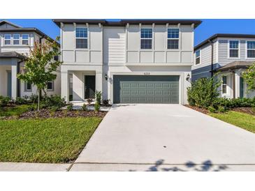 Charming two-story home with a manicured front yard and a two-car garage and a concrete driveway at 6233 Golden Beach Dr, Apollo Beach, FL 33572
